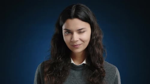 A Happy Girl Winks One Eye at the Camera and Smiles Sincerely