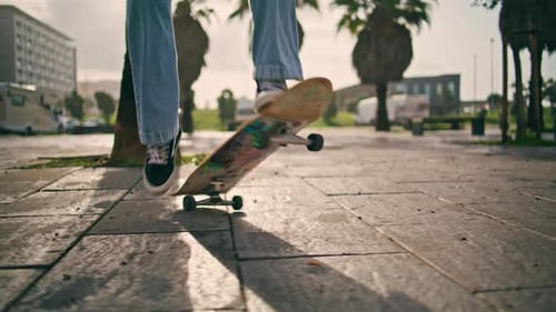Skateboarder Cruising Down Urban Street on Sunny Day