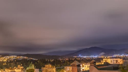 Night Time lapse of city with clouds and stars