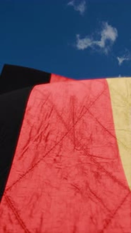 Waving National Flag Against Clear Blue Sky