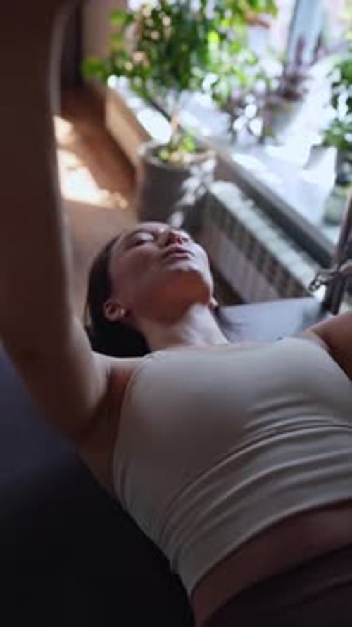 Woman Doing Pilates Exercises with Instructor on Balanced Body Cadillac Machine at Studio Focusing