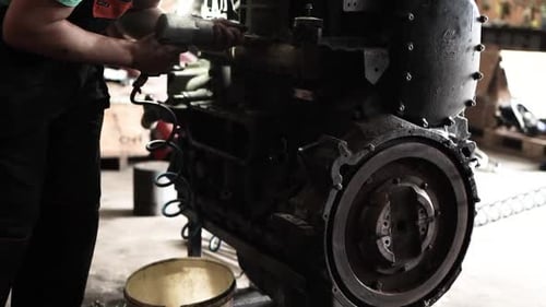 Mechanic Works on Diesel Engine with Power Tool