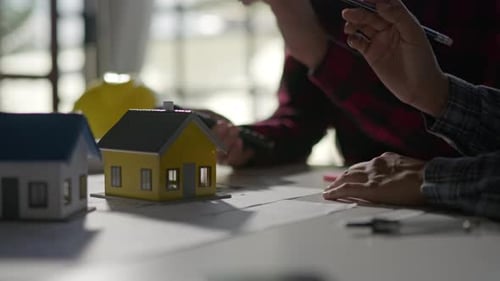 Hands working brainstorming and measuring for cost estimating on architectural and engineering.