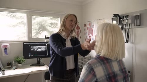 Female Primary Care Physician Examining Patient In Clinic Exam Room