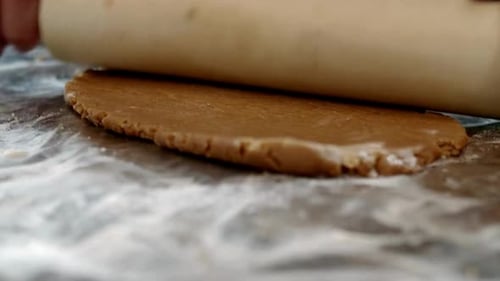 Rolling and Cutting Gingerbread Cookies in Kitchen