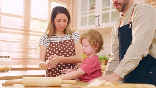 Caucasian attractive couple baking bakery with son in kitchen at home.
