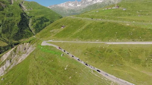 Scenic High Mountain Road Passing Through Lush Green Alpine Slopes