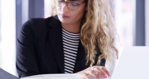 4k video footage of a young businesswoman using a laptop in a modern office