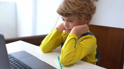 Worried Boy Using Laptop for Online School at Home