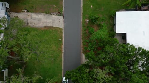 Straight down low flying aerial establishing shot of residential street in Tampa Florida surrounded