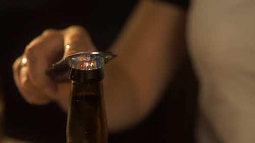 Girl pops a beer bottle open