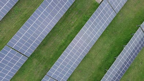 Aerial View of Solar Panel Array on Green Field
