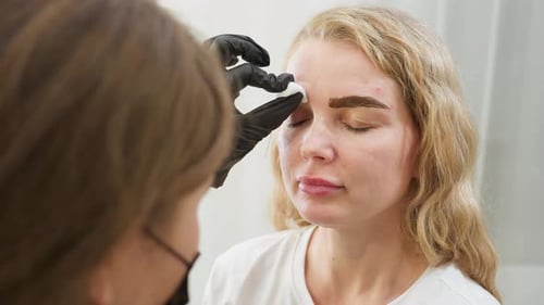 Woman Getting Eyebrow Treatment in Beauty Salon