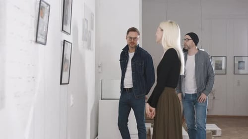 Men and Women in an Art Gallery Inspect the Abstract Works of Contemporary Artists