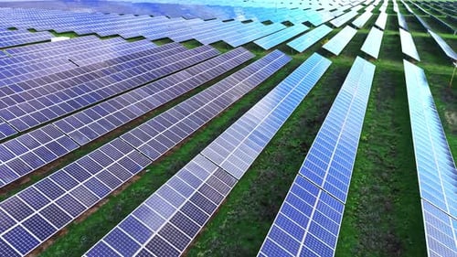 Solar panels cover vast fields in an aerial view of renewable energy site