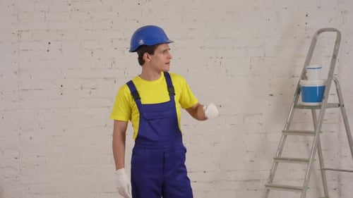 Construction Worker Smiles in front of Brick Wall