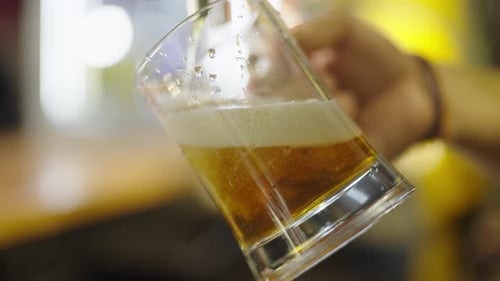 Frothy Beer Poured at a Bar Counter