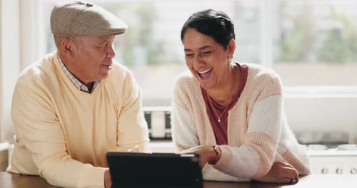 Senior Couple Enjoying Tablet at Kitchen Counter
