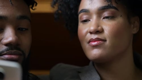 Pareja sincera que usa el teléfono en una conversación viendo comentarios de entretenimiento