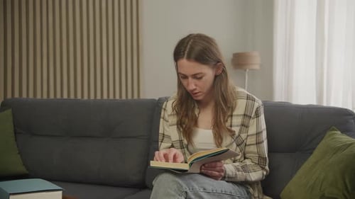 Woman Reading a Book on the Couch