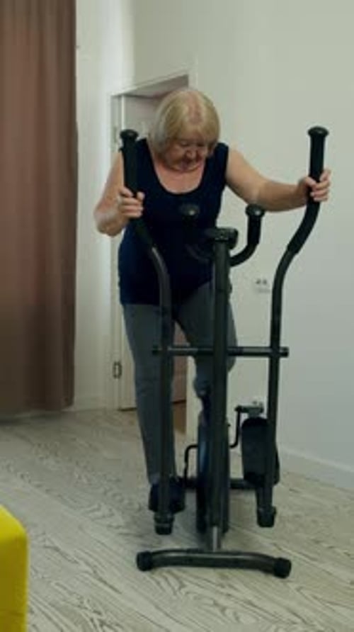 Elderly Woman Watching Television Holding Remote Control
