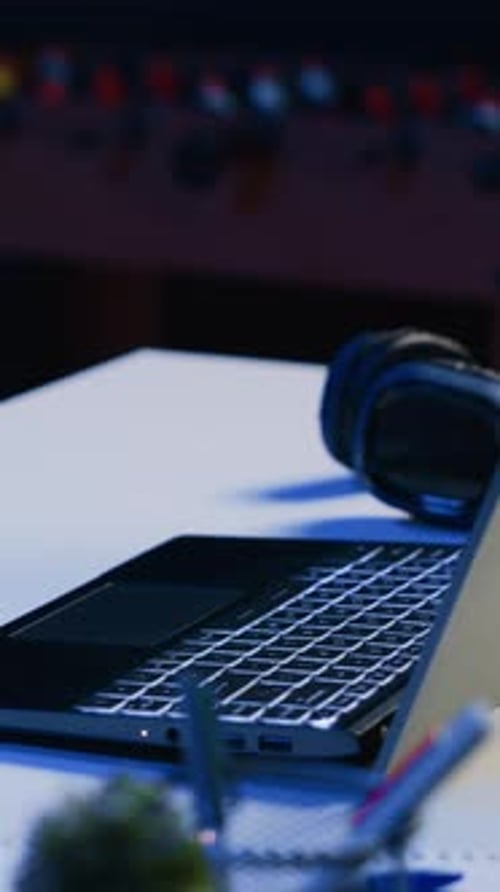 Vertical Video Close Up Shot of Personal Office Desk with Laptop and Headphones in Living Room