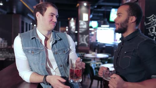 Deux amis tintent des verres à bière dans un bar animé