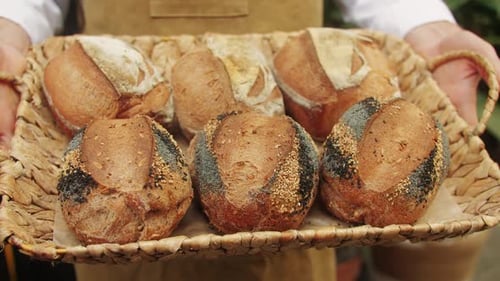 Der Bäcker hält in den Händen eine Nahaufnahme von frischem Brot, das von erfahrenen Bäckern hergestellt wird