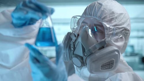 Laborwissenschaftler analysiert Pharmazeutikschlauch mit Atemschutzmaske