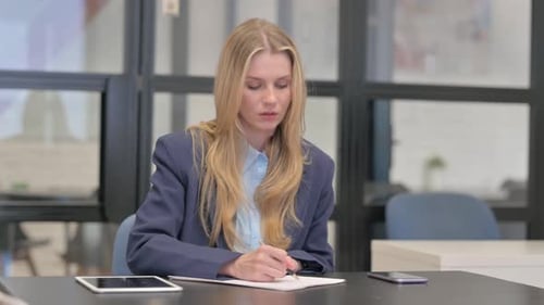 Young Businesswoman Writing a Letter in Office
