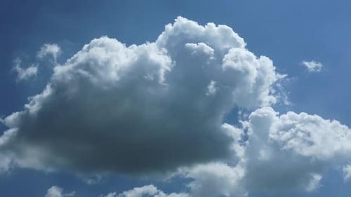 Fluffy White Clouds Float Across a Clear Blue Sky