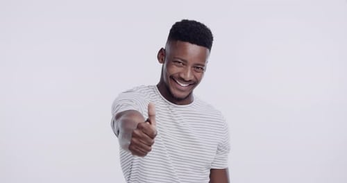Happy, thumbs up and face of black man in studio isolated on a white background