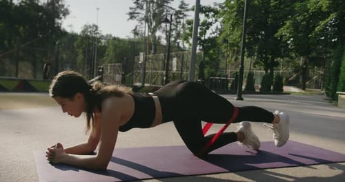 Woman Doing Glute Exercise With Resistance Band Outdoors