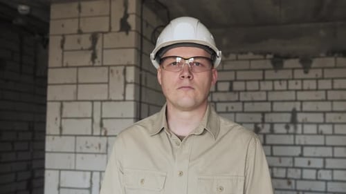 Porträt eines Ingenieurs, der in einem Raum steht und in die Kamera schaut