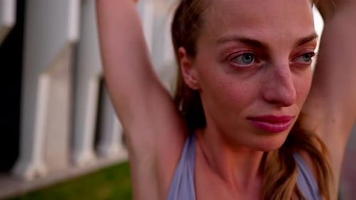 Woman Stretches Before Workout Outdoors Near Building