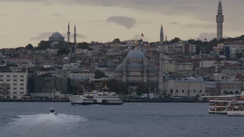 The view of the ferries and the city at sunset on the Bosphorus, the view of the famous historical m