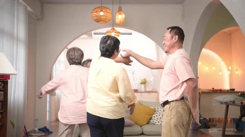 Seniors Dancing Together with Caregiver in Bright Home