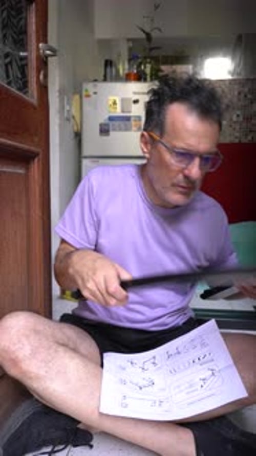 Homme analysant les instructions de montage étape par étape pour les meubles de bricolage