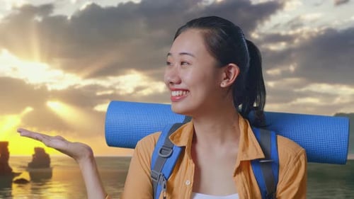 Close Up Of Asian Female Hiker Smiling And Pointing To Side on Beach