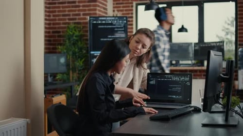 Software Development Team Compares Software Algorithms on Laptop Screen