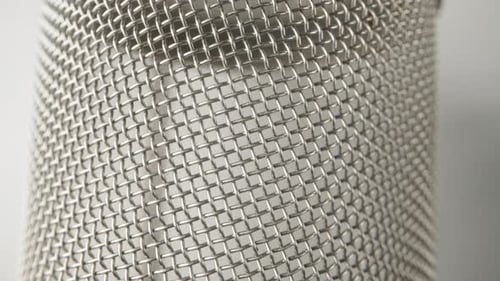 A glass for tea made of metal mesh. Dolly slider extreme close-up.