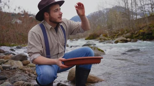 Smiling and Happy Portrait of a Male Gold Digger with Wash Gold Panning Mining