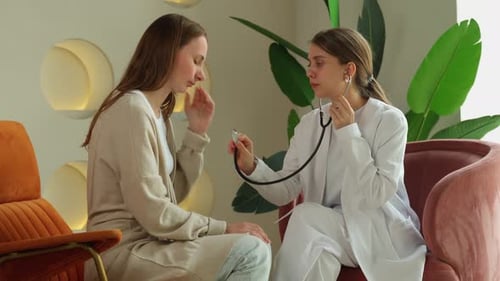 Doctor Examining Young Woman Patient in Office