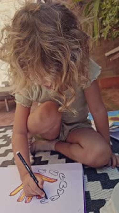 Niña con bolígrafos de colores dibujando en vertical