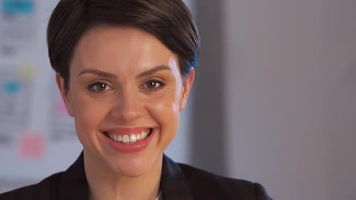 Happy young businesswoman smiling in a night office portrait slow motion