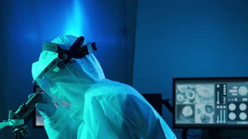 Scientist Examining Specimen Under Microscope in Lab