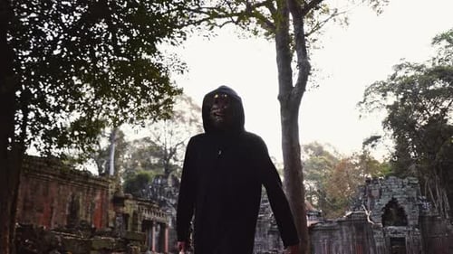 Hooded Figure with Sword in Ancient Ruins