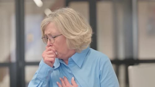 Portrait of Coughing Sick Senior Old Woman in Office