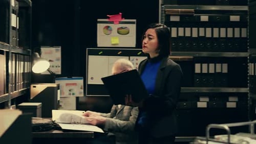 Colleagues Working in a Dark Office Filing System