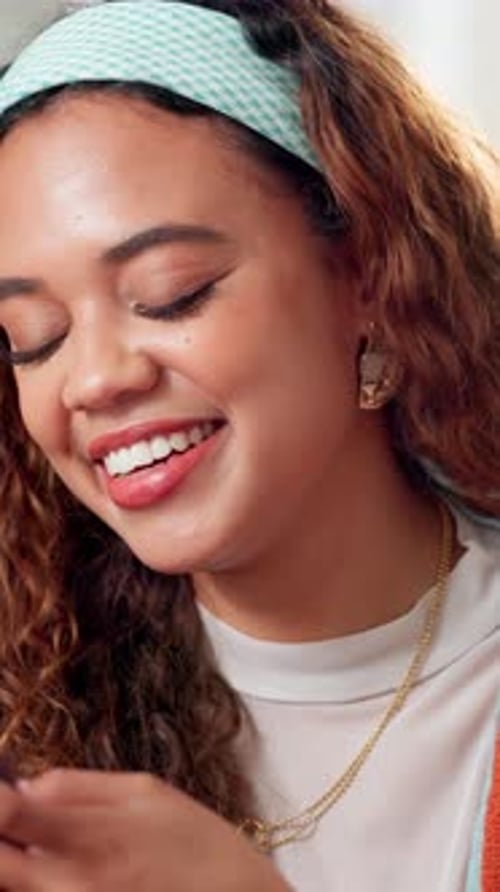 Smiling Young Woman Using a Mobile Phone Indoors